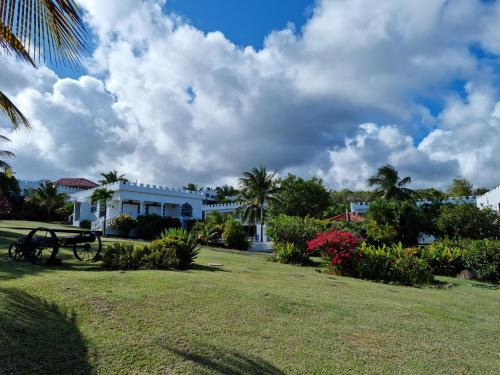 a white house with a large yard in front of it at Castles In Paradise Villa Resort in Vieux Fort
