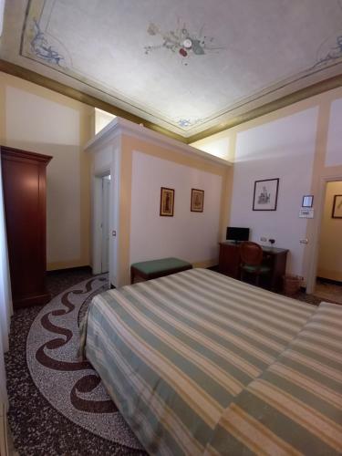 a hotel room with a bed and a desk at Villa Viola in Tortona