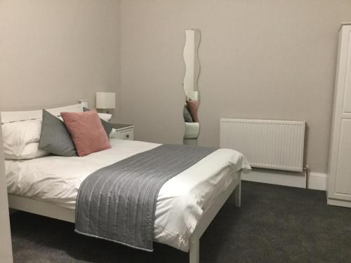 una camera con un letto bianco e una sedia di Amaryllis Guest House a Edimburgo