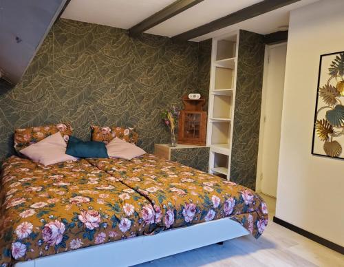 una camera da letto con un letto con copriletto floreale di Luxe vakantiehuisje in prachtige en rustgevende omgeving a Nieuwe-Niedorp
