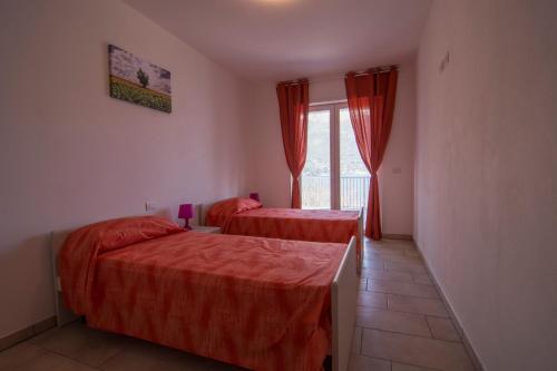 a bedroom with two beds and a window at Residence Il Poggio in Dorio