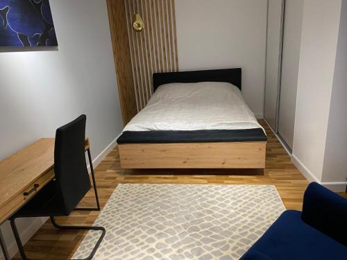 a small bedroom with a bed and a desk at Kamienica Nova 13 in Krosno