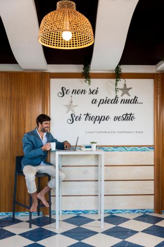 a man sitting at a desk with a laptop at Luxor Beach Boutique Hotel Cattolica in Cattolica