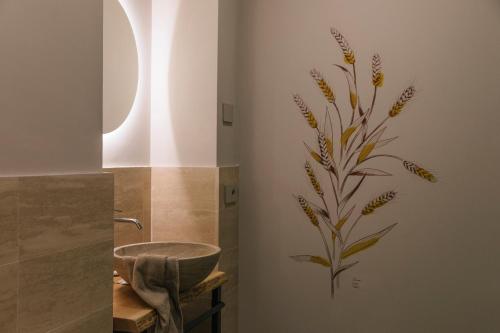 a bathroom with a flower mural on the wall at Relais Cocci Grifoni - Panoramic Wine Resort in Offida