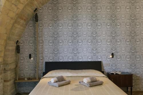 a bedroom with a bed with two pillows on it at Relais Cocci Grifoni - Panoramic Wine Resort in Offida