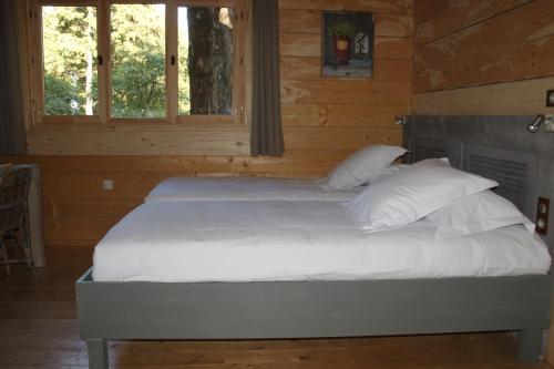 Кровать или кровати в номере Les Cabanes Dans Les Bois Logis Hôtel
