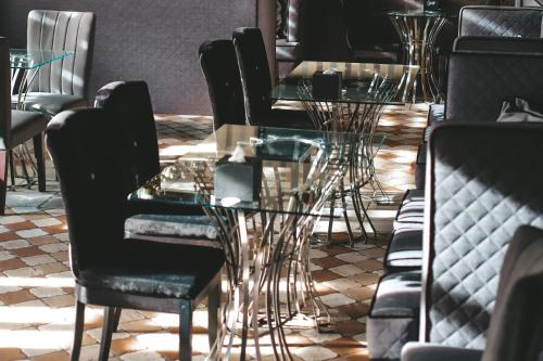 a dining room with tables and black chairs at Georg Palace Hotel in Chernivtsi