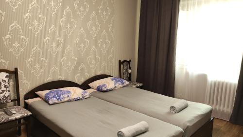 a bedroom with two beds with pillows and a window at Василя Стуса 10/77 City Rooms in Bila Tserkva