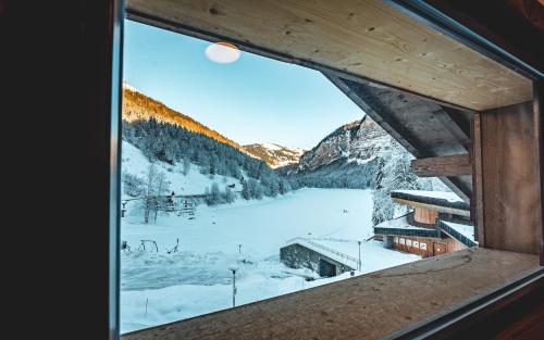 a view from a window of a snow covered mountain at Hotel Du Lac in Montriond