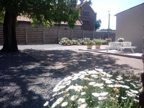 a picnic table in a garden with flowers at Natuurschoon Vakantiewoning Moorsel in Moorsel