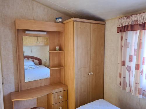 a small bedroom with a bunk bed and a mirror at 8 Berth Northshore (The Westmorland) in Lincolnshire