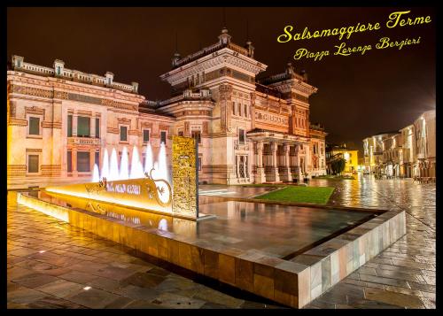 a building with a fountain in front of it at night at Hotel Ristorante San Carlo in Salsomaggiore Terme