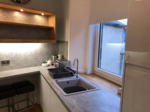 a small kitchen with a sink and a window at Pier Head in Largs