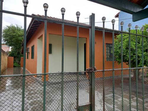 a house behind a fence with a gate at Casa Aconchegante in São Sebastião