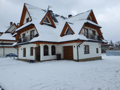 ein Haus mit Schnee auf dem Dach in der Unterkunft DW Na Równi Białka Tatrzańska in Białka Tatrzańska