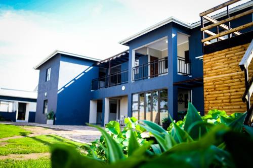 um edifício azul com plantas em frente em Happy Hen Guest Lodge em Bizana