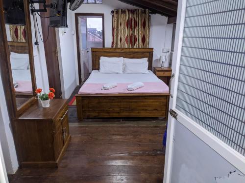una piccola camera con letto e specchio di Lighthouse Guest a Galle