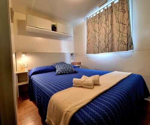 a bedroom with a blue bed with a blue blanket at Villaggio Acquamarina in Pisciotta