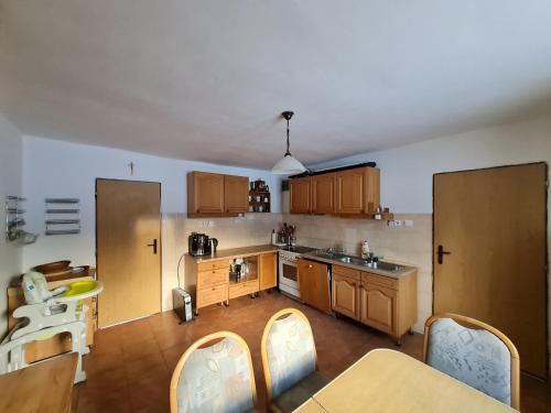 a kitchen with wooden cabinets and a table and chairs at Starý dom in Oravská Polhora