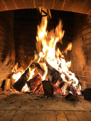 a fire in a brick oven with flames at Anarada Guesthouse in Synikia Mesi Trikalon
