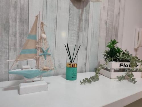a white table with a toy sailboat and potted plants at Big Wave House in Nazaré