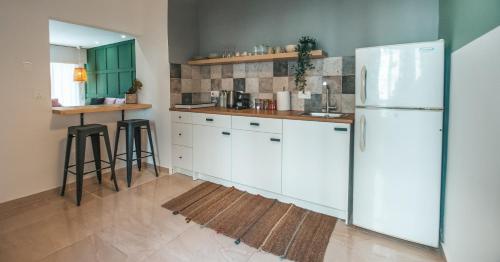 a kitchen with white cabinets and a white refrigerator at Designer 2-Bedroom Apartment 150m from Mackenzie Beach in Larnaca