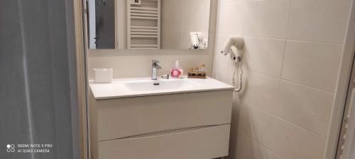 uma casa de banho branca com um lavatório e um espelho em Appartement vacances Marseille em Marselha