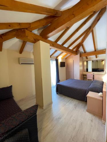 a bedroom with two beds and a couch at Lo Scoiattolo in Massino Visconti