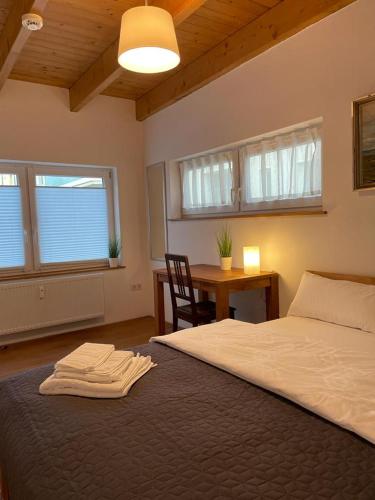 a bedroom with a bed and a table and windows at Ferienwohnung im Stadtzentrum von Bernau - Komfortable Wohnung mit 2 Zimmern, Bad, Spülmaschine, Waschmaschine, komplette Küche, WLAN, Terrasse, ruhige Lage in Bernau bei Berlin