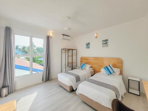 a bedroom with two beds and a window at Hudhufas Villa in Thoddoo