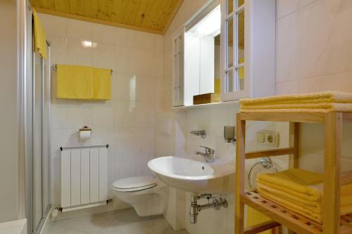 a white bathroom with a sink and a toilet at Ferienwohnung Scheffau in Scheffau am Wilden Kaiser