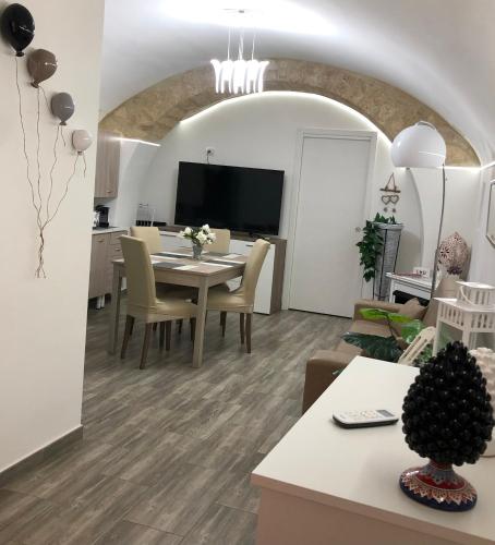 a dining room and living room with a table and chairs at Dimora Vittoria in Bari