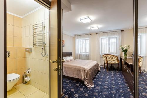ein Hotelzimmer mit einem Bett und einem Bad in der Unterkunft Incognito Boutique Hotel in Kiew