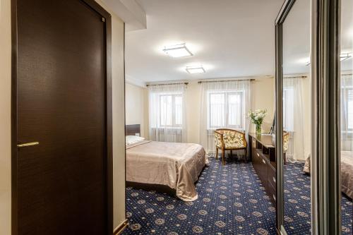 ein Hotelzimmer mit einem Bett, einem Schreibtisch und einem Schlafzimmer in der Unterkunft Incognito Boutique Hotel in Kiew