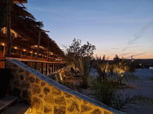 een resort met een stenen muur naast een gebouw bij Selina Desert Garden Ramon in Mitzpe Ramon