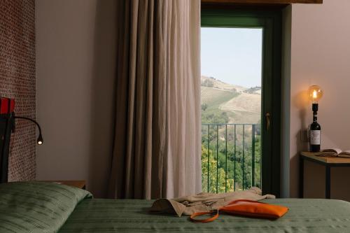 a bedroom with a bed and a window with a view at Relais Cocci Grifoni - Panoramic Wine Resort in Offida