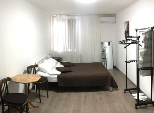 Мини Отель «Positive” في كييف: غرفة نوم بسرير وطاولة مع كراسي