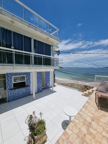 a house with a patio with a view of the ocean at Pousada Seven in Arraial do Cabo