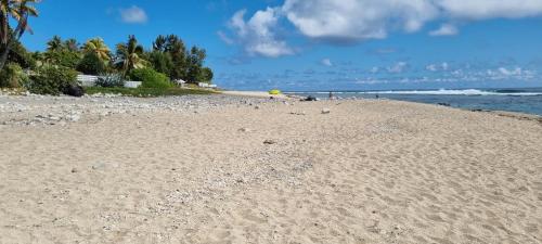 a sandy beach with a yellow frisbee on it at Appart Alexina, 2mn à pieds de la plage de BOUCAN-CANOT in Saint-Gilles les Bains