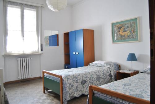 1 dormitorio con 2 camas y armario azul en Lombardi Fleming, en Parma
