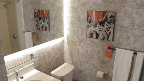 a bathroom with a toilet and two paintings on the wall at Howard Johnson by Wyndham Middletown Newport Area in Middletown
