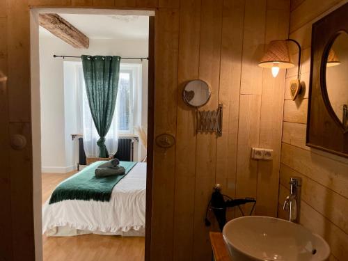 y baño con cama, lavabo y espejo. en La Naomath - Maison d'hôtes, Hébergement insolite & Gîte, en Bayeux
