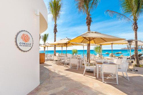 a restaurant on the beach with chairs and umbrellas at Villa La Valencia Beach Resort & Spa Los Cabos in San José del Cabo