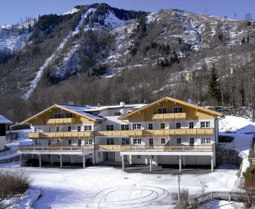 un gran edificio en la nieve frente a una montaña en Alpinresort Kaprun 4, en Kaprun