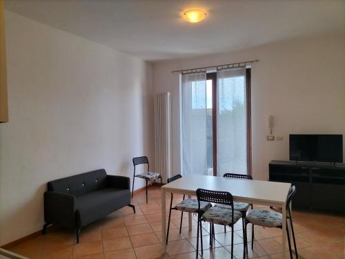 a living room with a table and chairs and a couch at Casa Degli Ulivi in Lazise