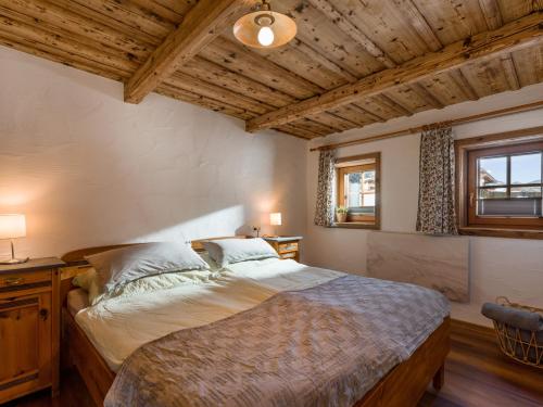 a bedroom with a large bed and a wooden ceiling at Sabindls Kaiser Platzl in Going