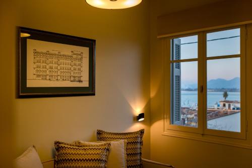 納夫普利翁的住宿－勒托努埃沃酒店，带2把椅子和窗户的房间