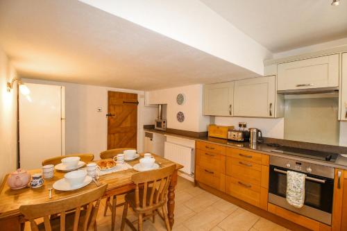 a kitchen with a wooden table with chairs and a dining room at Cajun Cottage in Wareham