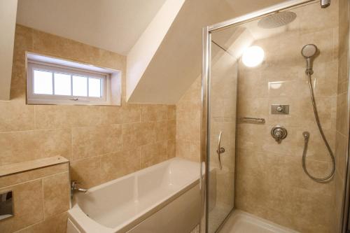 ein Badezimmer mit Dusche und Badewanne in der Unterkunft Cajun Cottage in Wareham