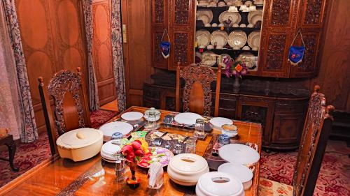un comedor con una mesa con platos y flores. en Dal Lake Heritage Houseboat New Manila, en Srinagar